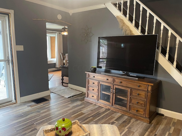 living room featuring dark hardwood / wood-style floors, plenty of natural light, ornamental molding, and ceiling fan