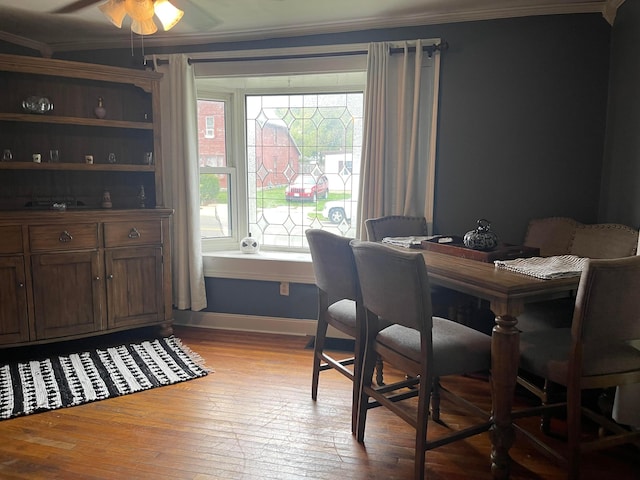 dining area featuring light wood-type flooring, ceiling fan, and ornamental molding