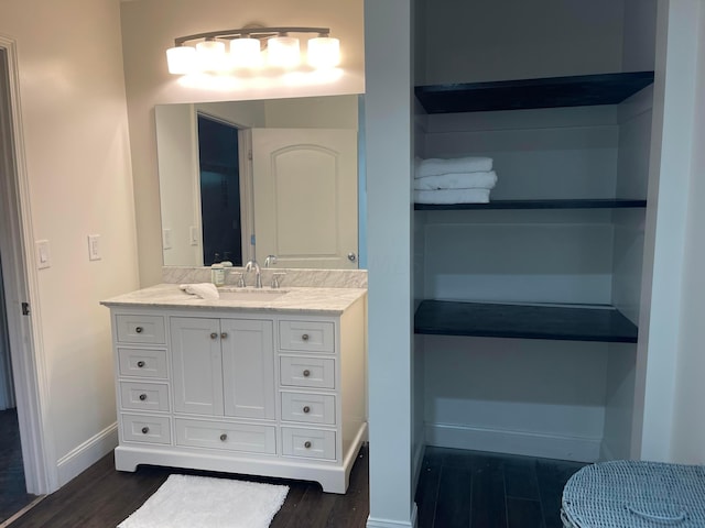 bathroom featuring built in shelves, wood-type flooring, and vanity