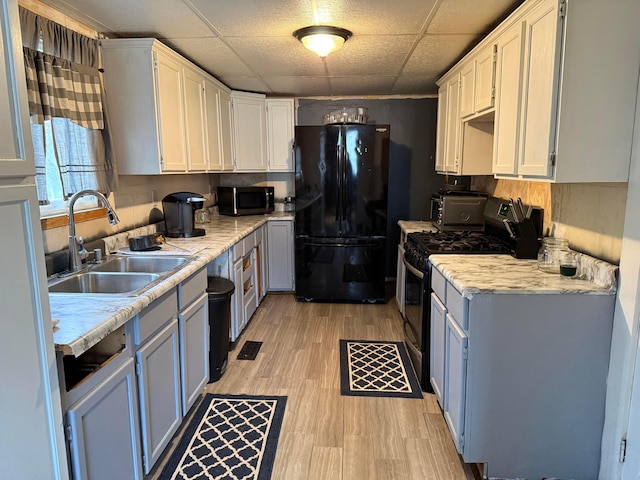 kitchen featuring white cabinetry, appliances with stainless steel finishes, sink, and light hardwood / wood-style floors