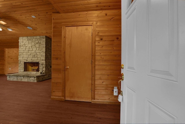 interior space featuring a fireplace, wood walls, dark wood-type flooring, and wood ceiling