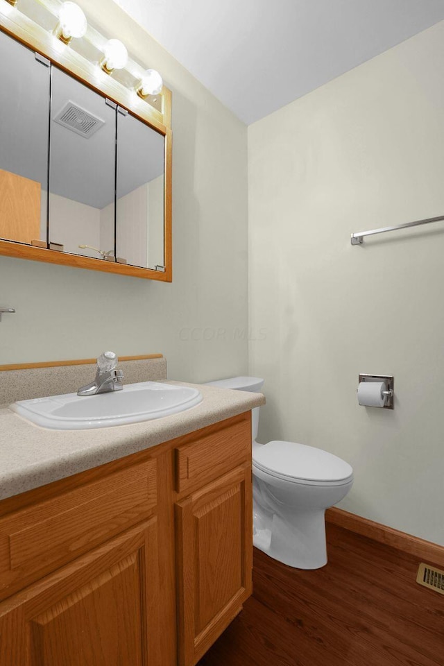 bathroom featuring hardwood / wood-style floors, vanity, and toilet