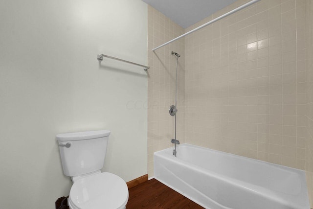 bathroom with hardwood / wood-style floors, tiled shower / bath combo, and toilet