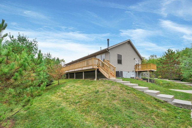 rear view of house featuring a lawn, a wooden deck, and central AC