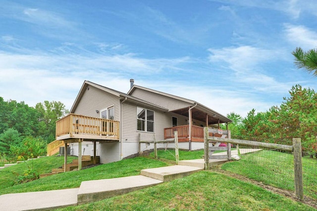 rear view of house with a lawn and a wooden deck