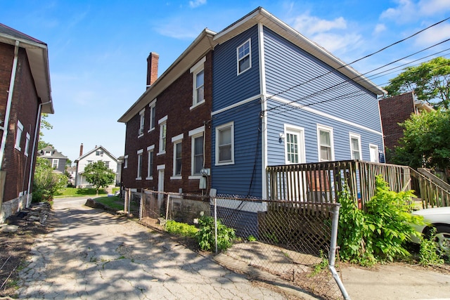 2395 Summit St, Columbus, OH 43202 - view of property exterior with a chimney and a wooden deck