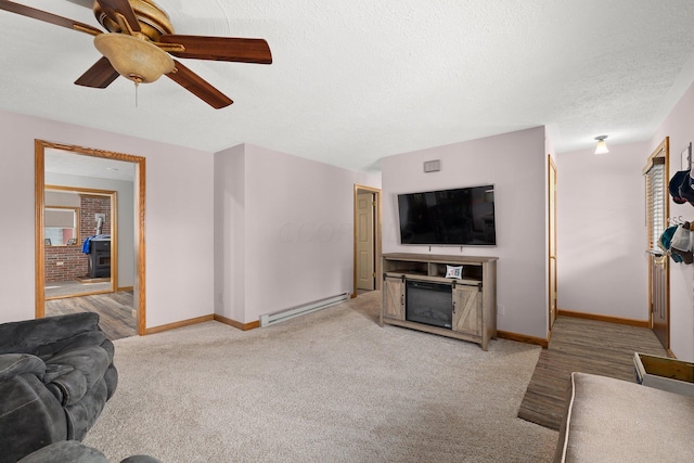 living room with a textured ceiling, ceiling fan, light colored carpet, and baseboard heating