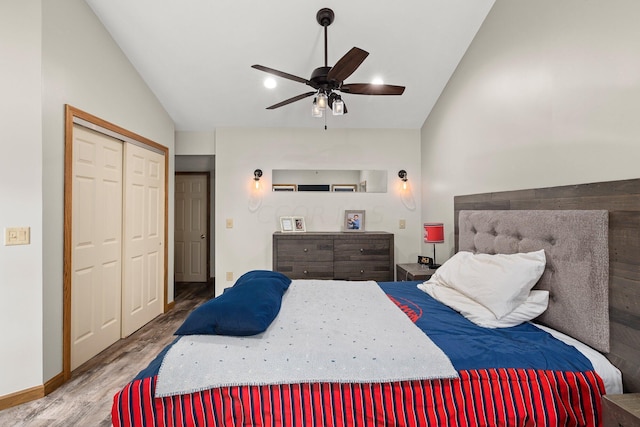 bedroom featuring lofted ceiling, ceiling fan, light wood-type flooring, and a closet