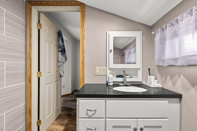 bathroom featuring vanity, vaulted ceiling, and hardwood / wood-style flooring