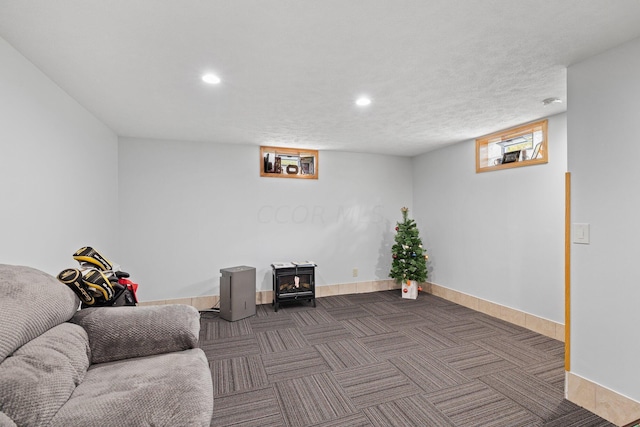 sitting room with dark colored carpet and a textured ceiling