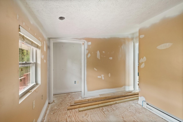 empty room with a textured ceiling and a baseboard radiator