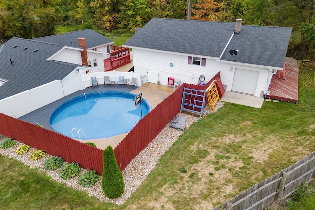 view of swimming pool featuring a lawn and a wooden deck