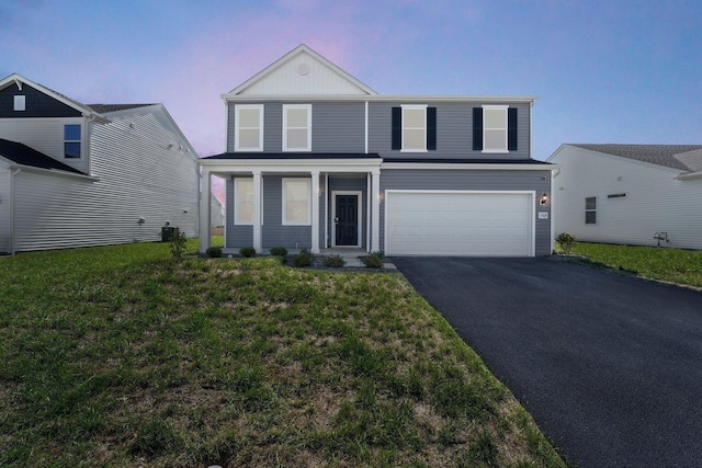 view of front property featuring a lawn, cooling unit, and a garage