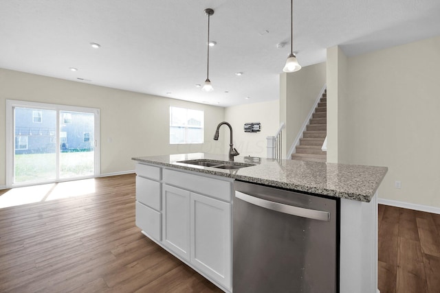 kitchen featuring sink, stainless steel dishwasher, pendant lighting, light hardwood / wood-style floors, and white cabinets