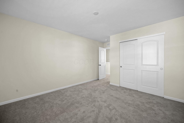 unfurnished bedroom featuring carpet floors and a closet