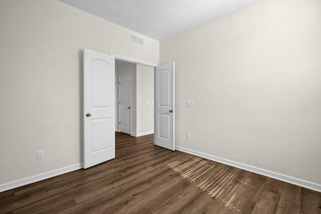 unfurnished bedroom with dark hardwood / wood-style flooring