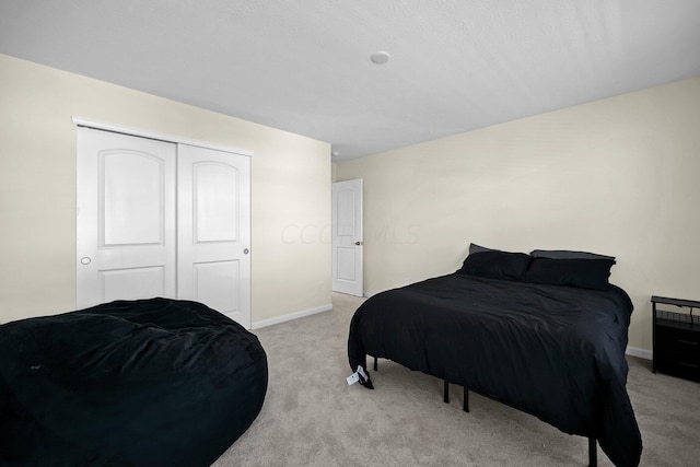 bedroom featuring light colored carpet and a closet