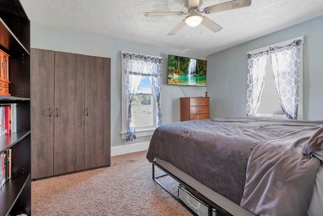 bedroom with a textured ceiling, light colored carpet, and ceiling fan