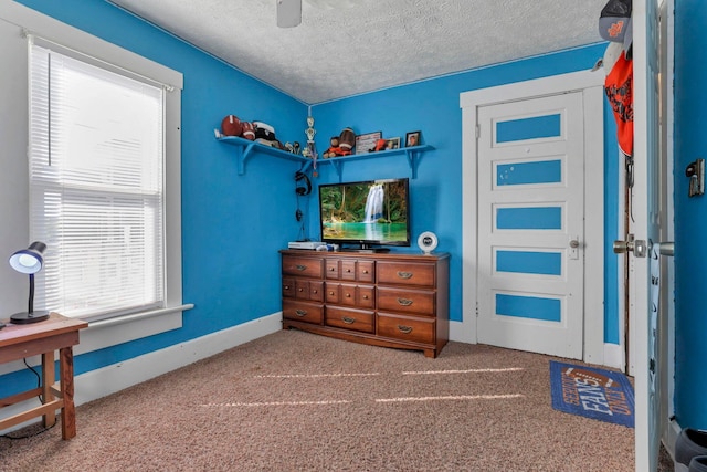 bedroom with carpet flooring, ceiling fan, and a textured ceiling