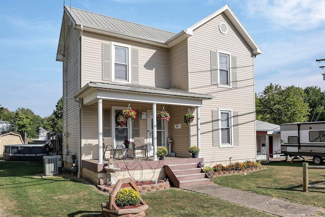 view of front facade featuring covered porch, central AC, and a front lawn