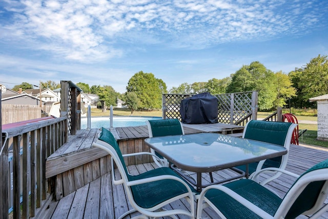 wooden terrace with area for grilling and a pool