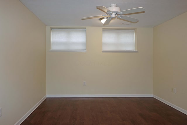 spare room featuring baseboards, visible vents, a ceiling fan, wood finished floors, and a healthy amount of sunlight