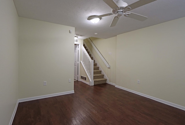 basement featuring baseboards, a textured ceiling, stairway, and wood finished floors