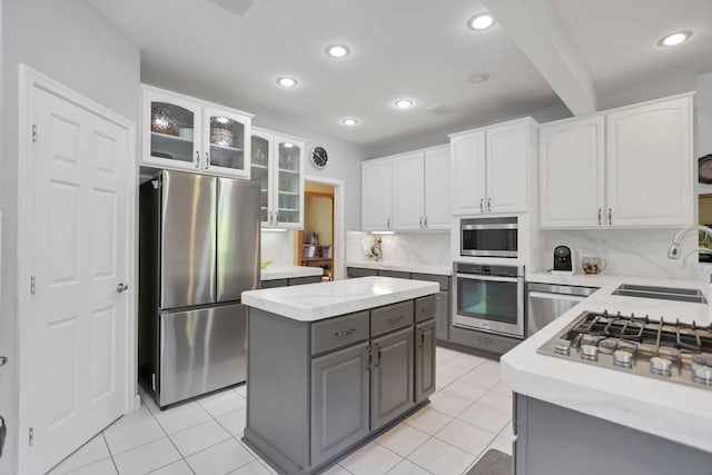 kitchen featuring decorative backsplash, appliances with stainless steel finishes, white cabinetry, and sink