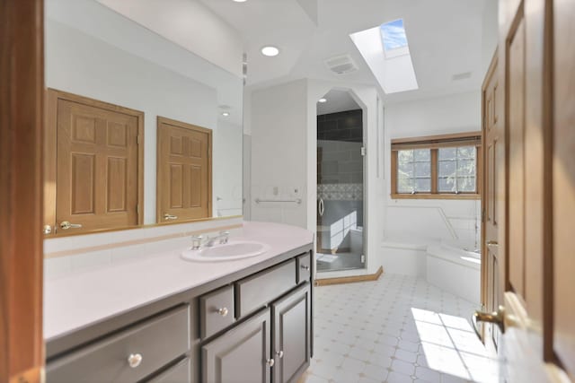 bathroom with vanity, a tub to relax in, and a skylight