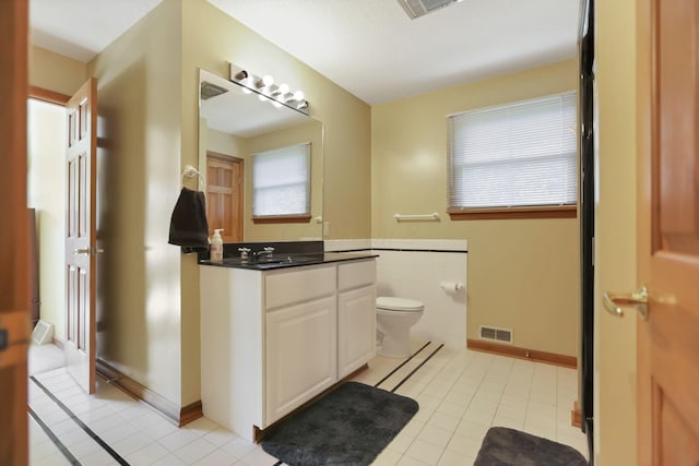 bathroom with tile patterned flooring, vanity, and toilet