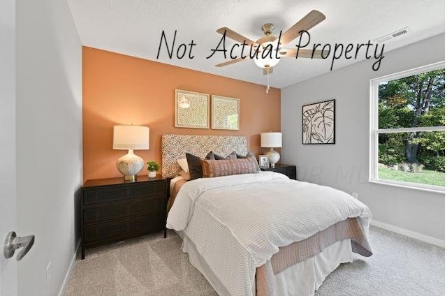 carpeted bedroom featuring multiple windows and ceiling fan