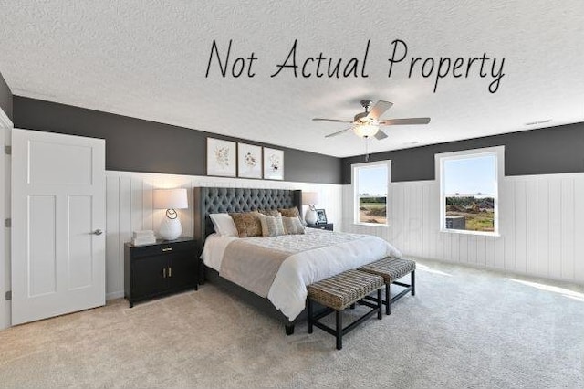 carpeted bedroom with a textured ceiling and ceiling fan