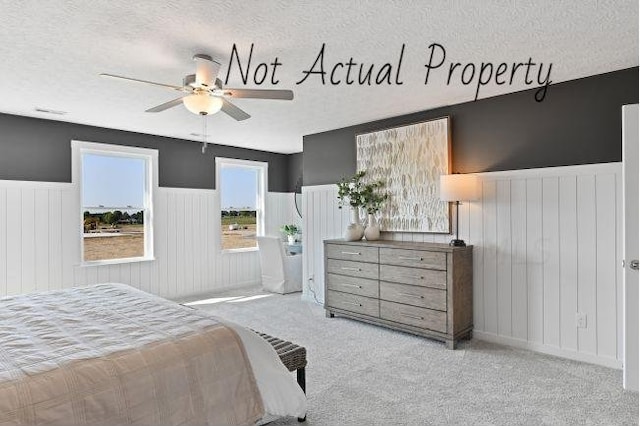 bedroom with light carpet, a textured ceiling, and ceiling fan