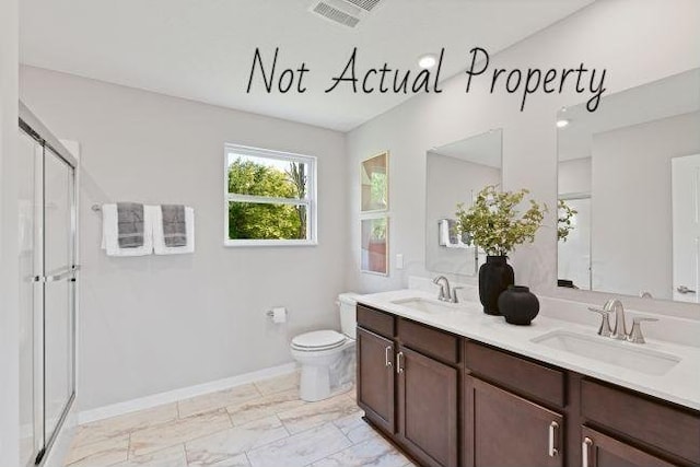 bathroom featuring toilet, vanity, and walk in shower