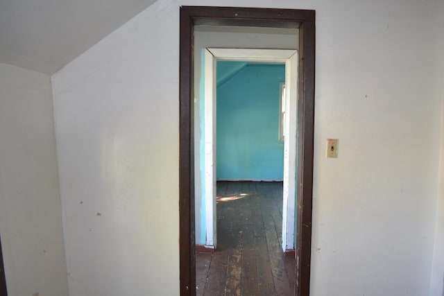 hallway featuring dark hardwood / wood-style flooring and vaulted ceiling