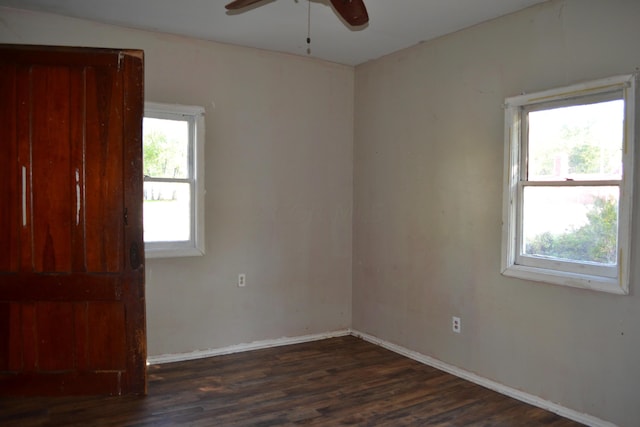 spare room with plenty of natural light, dark wood-type flooring, and ceiling fan