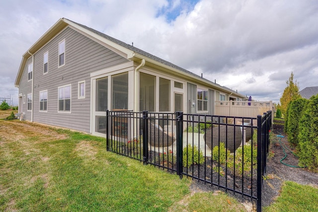 view of home's exterior featuring a lawn and a sunroom