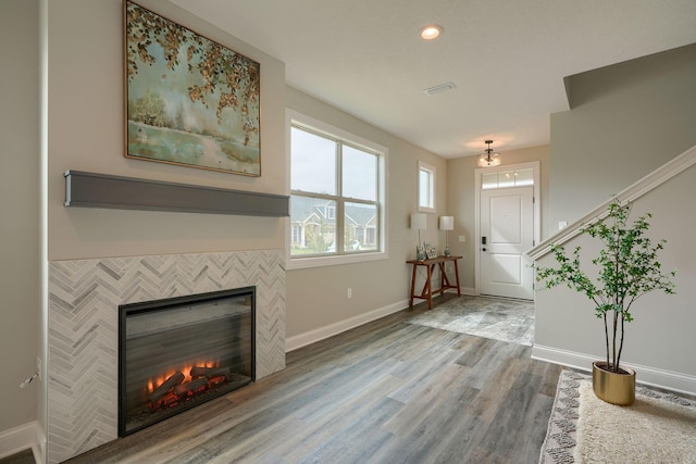 foyer featuring a tiled fireplace and hardwood / wood-style floors