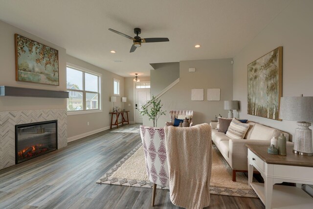 living room with hardwood / wood-style flooring, ceiling fan, and a fireplace