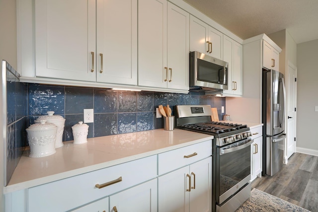 kitchen featuring tasteful backsplash, white cabinetry, dark hardwood / wood-style floors, and appliances with stainless steel finishes