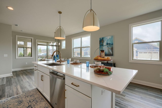 kitchen with sink, decorative light fixtures, a center island with sink, dishwasher, and white cabinetry