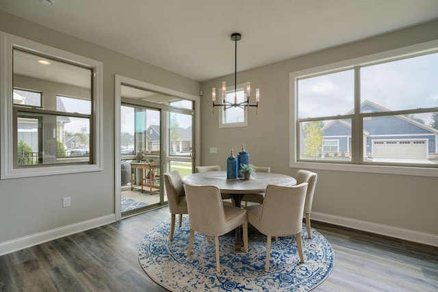 dining room with dark hardwood / wood-style floors and an inviting chandelier