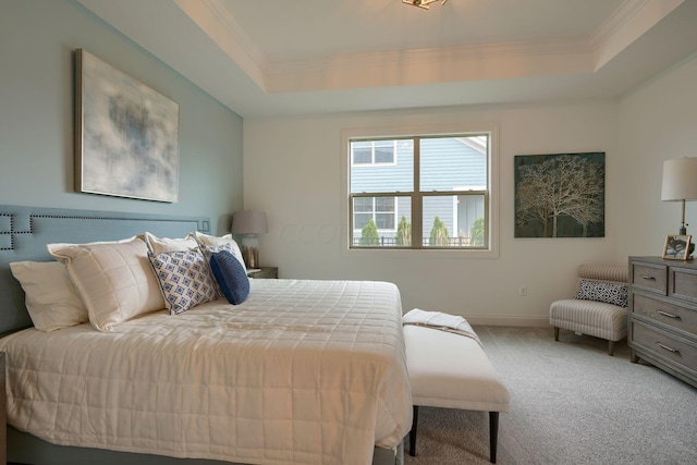 carpeted bedroom featuring a raised ceiling and ornamental molding