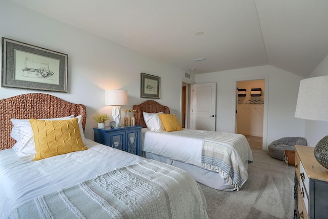 bedroom with a walk in closet, a closet, carpet, and vaulted ceiling