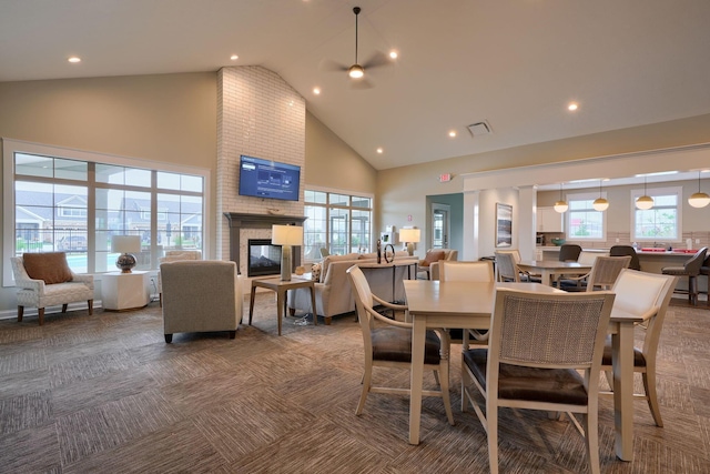 dining room with a fireplace, carpet flooring, high vaulted ceiling, and ceiling fan