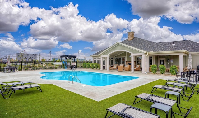 view of pool featuring a patio area and a yard