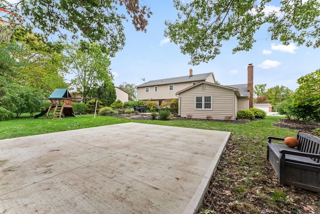 rear view of property with a yard and a playground