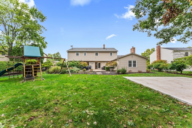 back of property featuring a playground and a yard