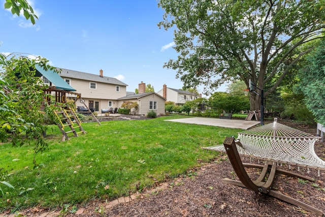 view of yard featuring a playground and a patio