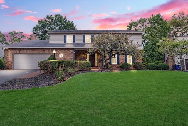 front facade featuring a garage and a lawn